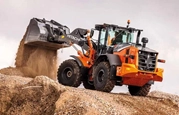 New Loader lifting dirt in field,New Hitachi Loader on construction site,Hitachi Loader moving dirt,Hitachi loader scoping up dirt,Hitachi loader scoping up dirt